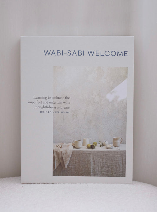 Coffee table book titled 'Wabi-Sabi Welcome' on a white surface with a neutral background